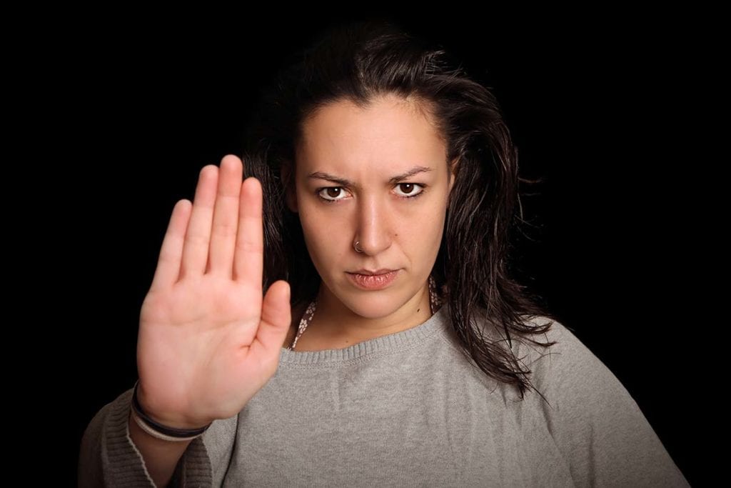 woman putting her hand up to make boundaries for addicts