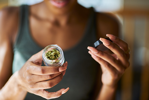 Woman holding a jar of marijuana who needs to know how to stop smoking weed