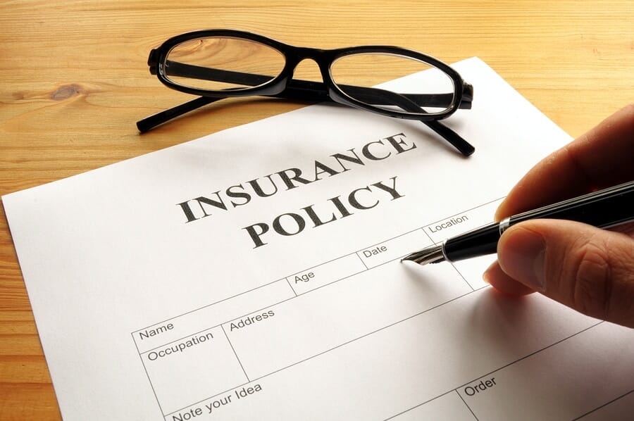 person filling out insurance policy wondering does insurance cover rehab
