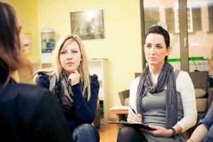 women speak with therapist at womens rehab center program