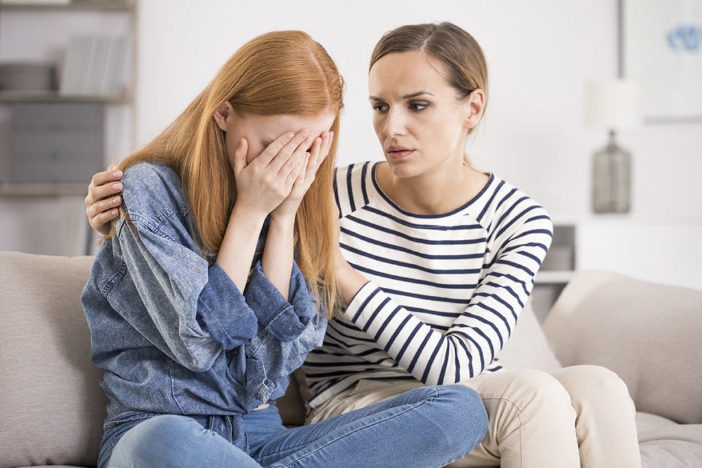 a woman comforts her friend who has seen the signs of codependency