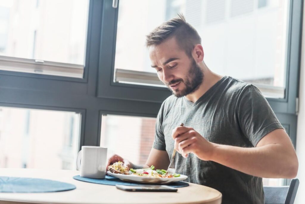 Man eating food after learning what kinds of food stop alcohol cravings