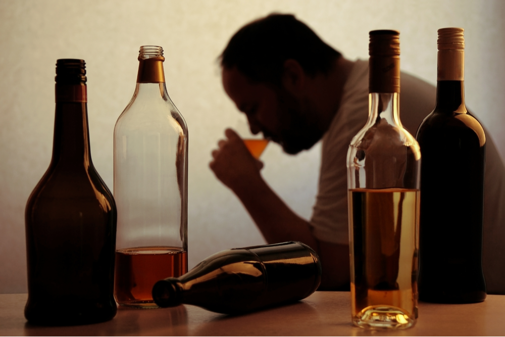 Older man drinking excessive alcohol suffering from stages of liver disease