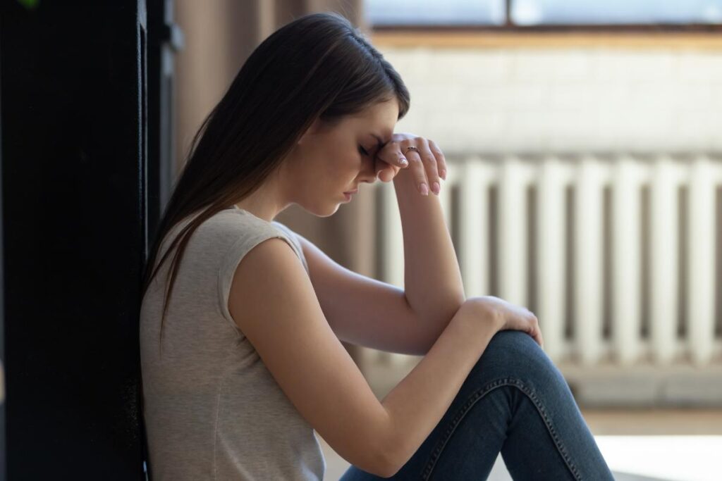 Woman with head on hands, struggling with long-term effects of marijuana use