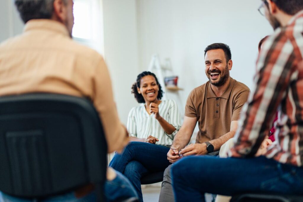 Clients sit and talk during a group therapy session, as they enjoy the benefits of IOP