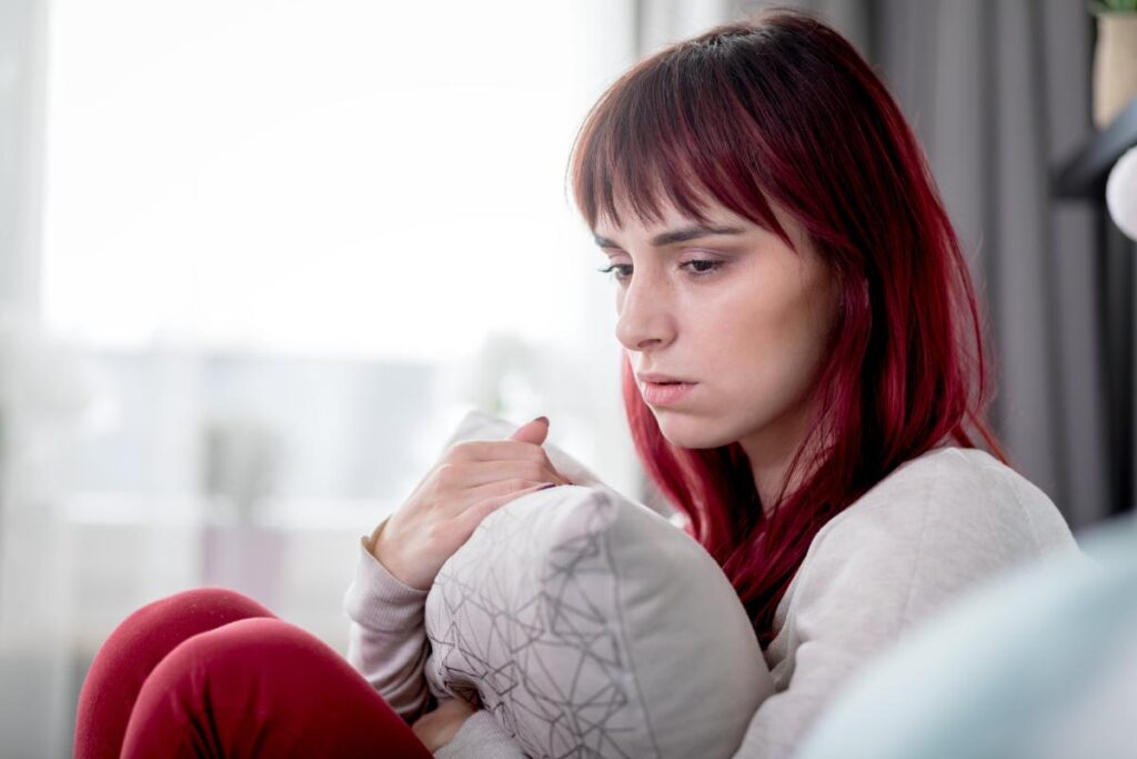 Woman hugs pillow as she ponders the most commonly abused drugs