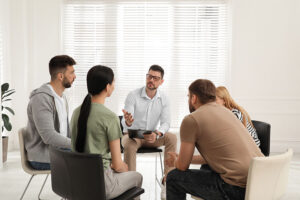People sit in group therapy during a drug detox program