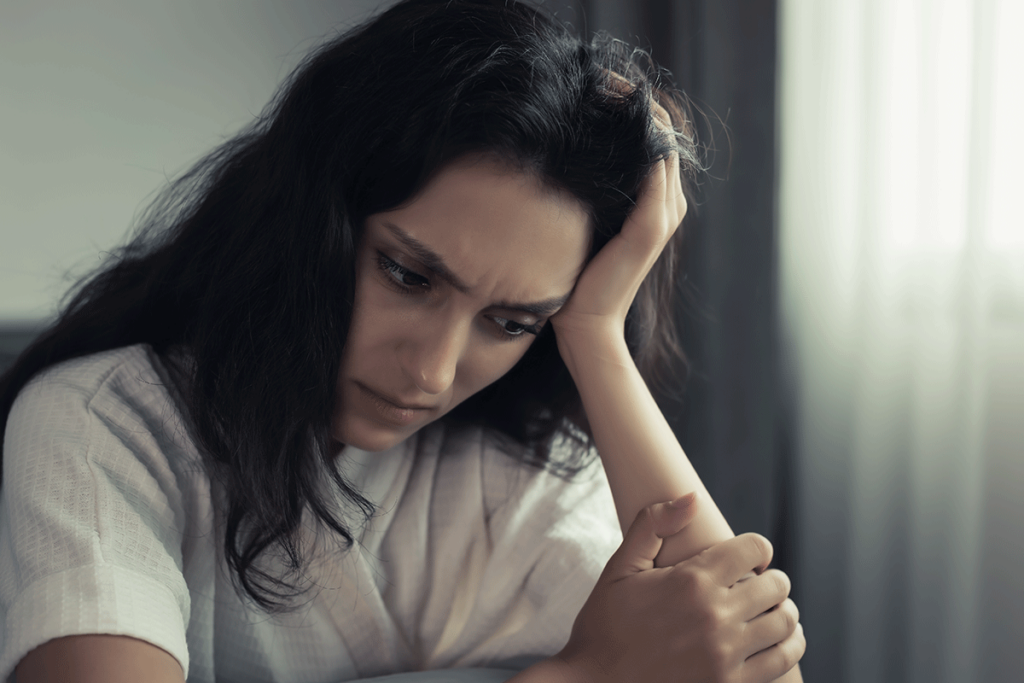 Woman puts head in hands and ponders if marijuana is a hallucinogen or not